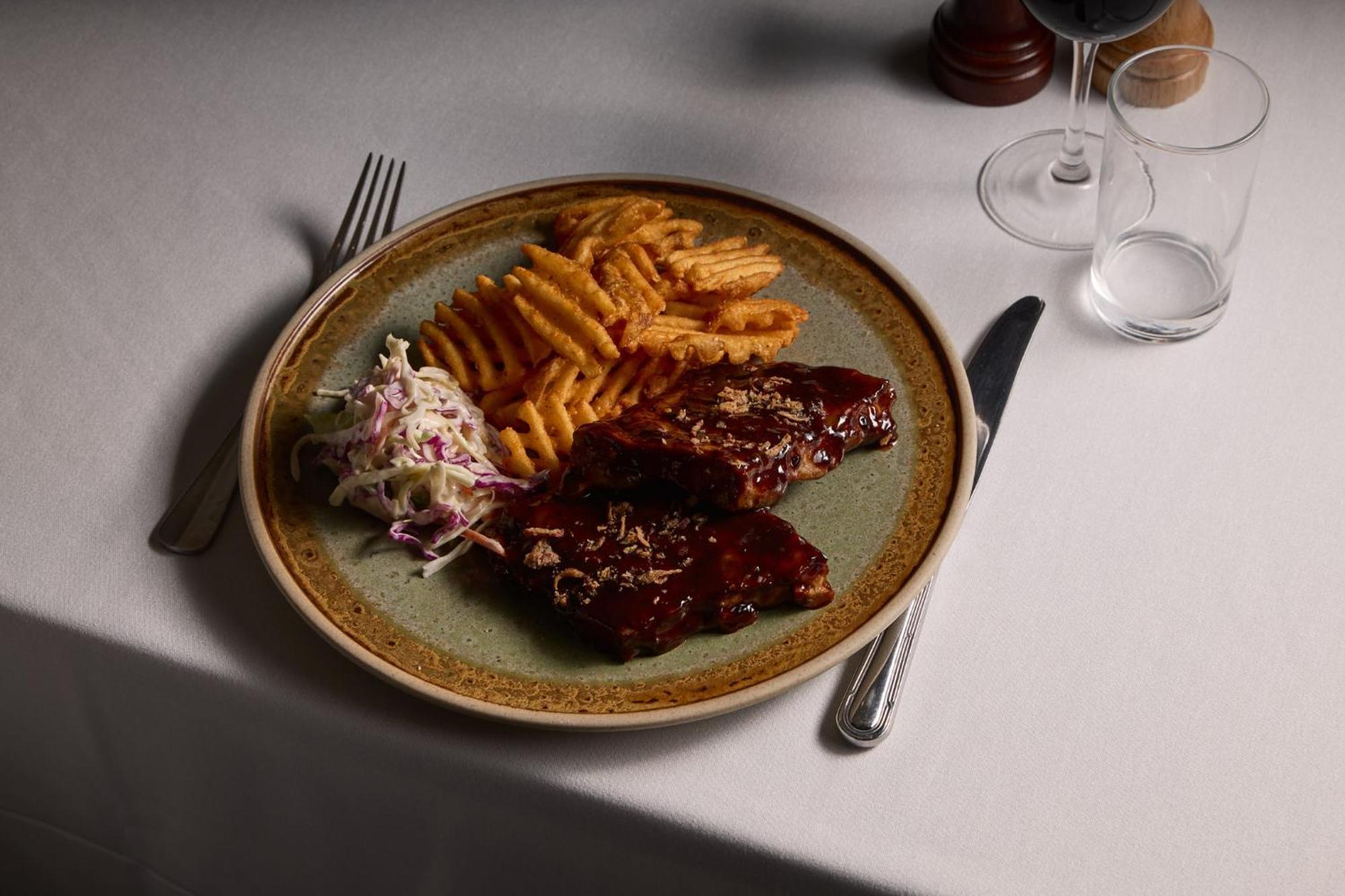 Отель Stamford Plaza Мельбурн Экстерьер фото The photo displays a plate of food featuring two pieces of steak that appear to be glazed with a rich sauce. Alongside the steak, there are crinkle-cut fries arranged neatly on one side of the plate. Additionally, there's a small serving of coleslaw,